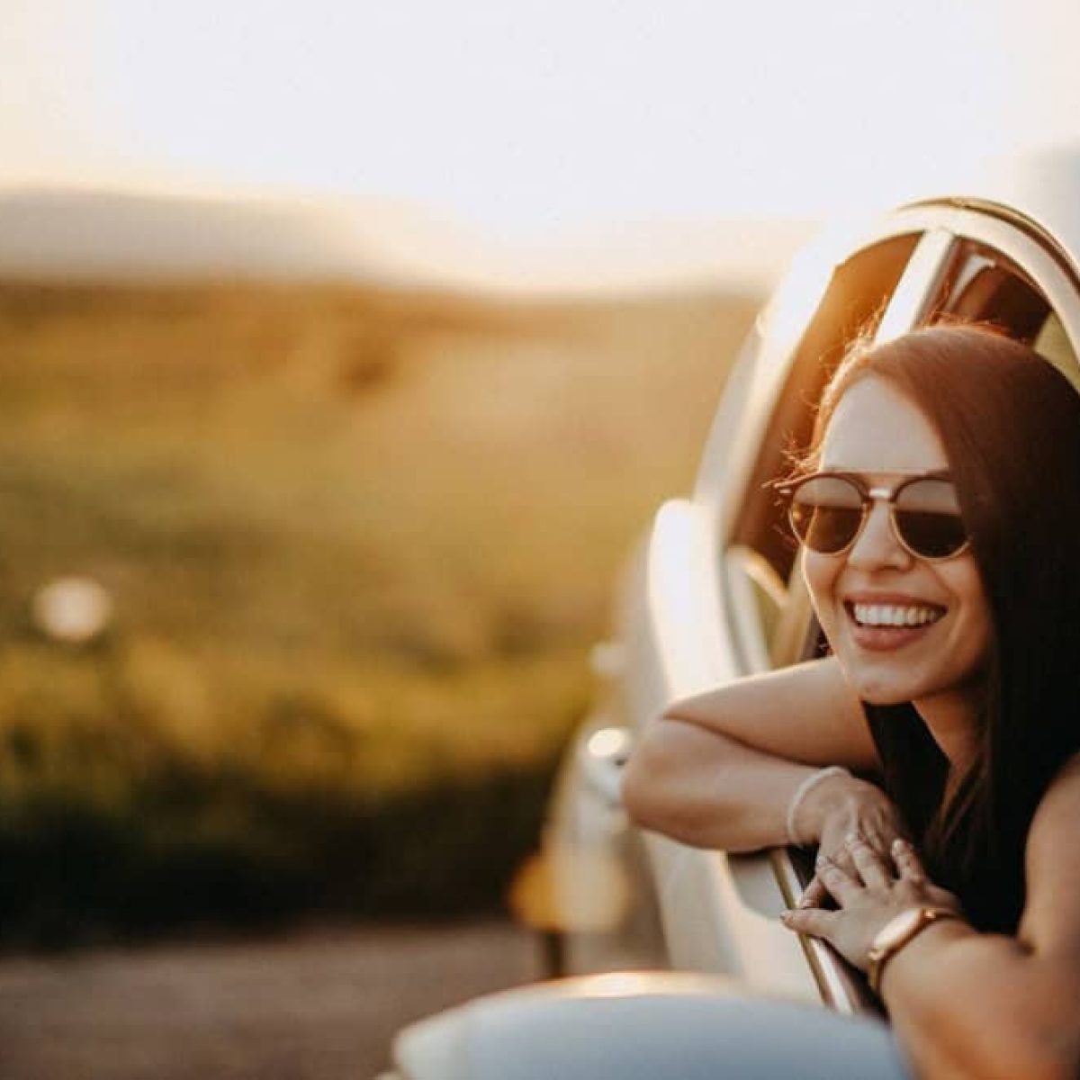 หญิงสาวสวมใส่แว่นกันแดดเลนส์ย้อมสีเพื่อปกป้องดวงตาจากแสงแดดขณะขับขี่รถยนต์